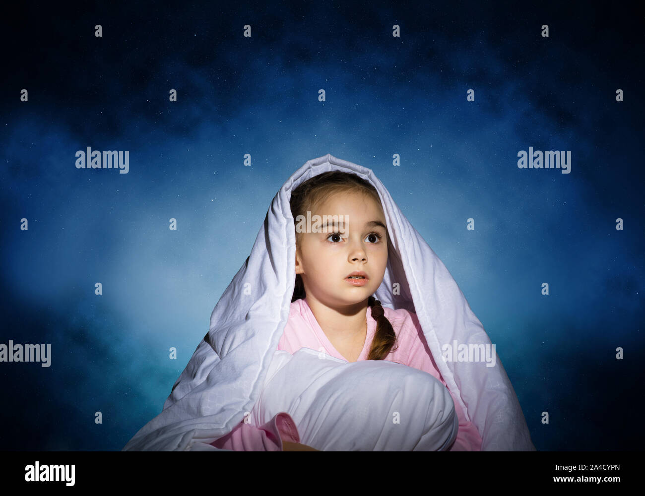 Scared girl with pillow hiding under blanket Stock Photo Alamy