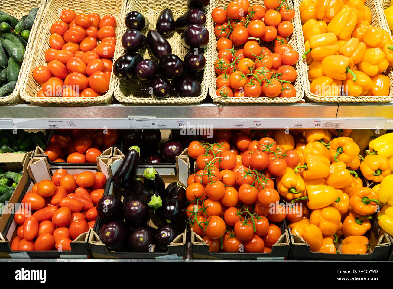 Market counter with wicker baskets and lug boxes with tomatoes, squash