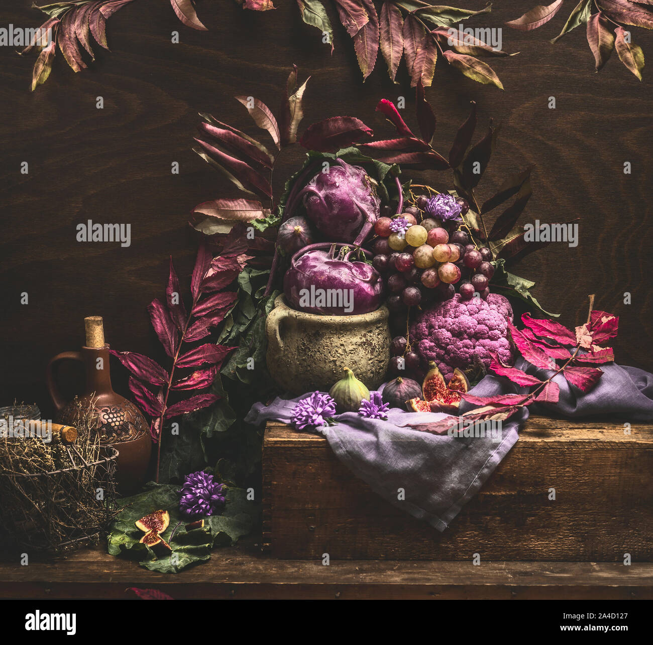 Still life with purple fruits and vegetables on wooden table with ...