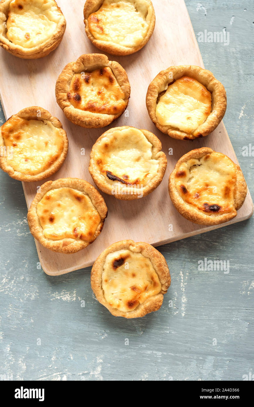 Pastel de Nata Portugese egg custard pies on blue background, top view, flat lay. Stock Photo