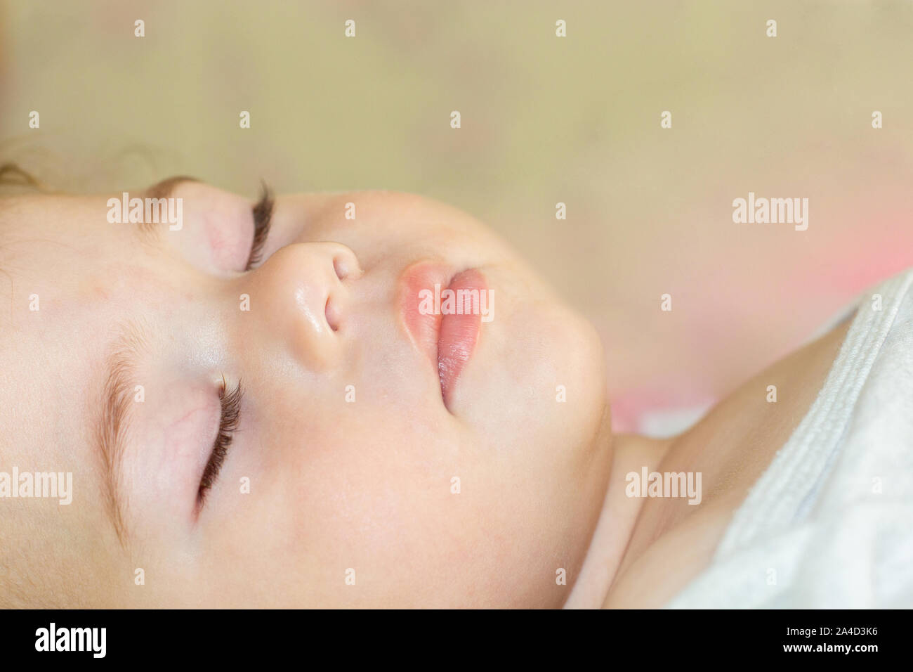 Face of a sleeping baby boy girl close-up. Portrait of a Caucasian child with closed eyes, eyebrows nose lips. Stock Photo