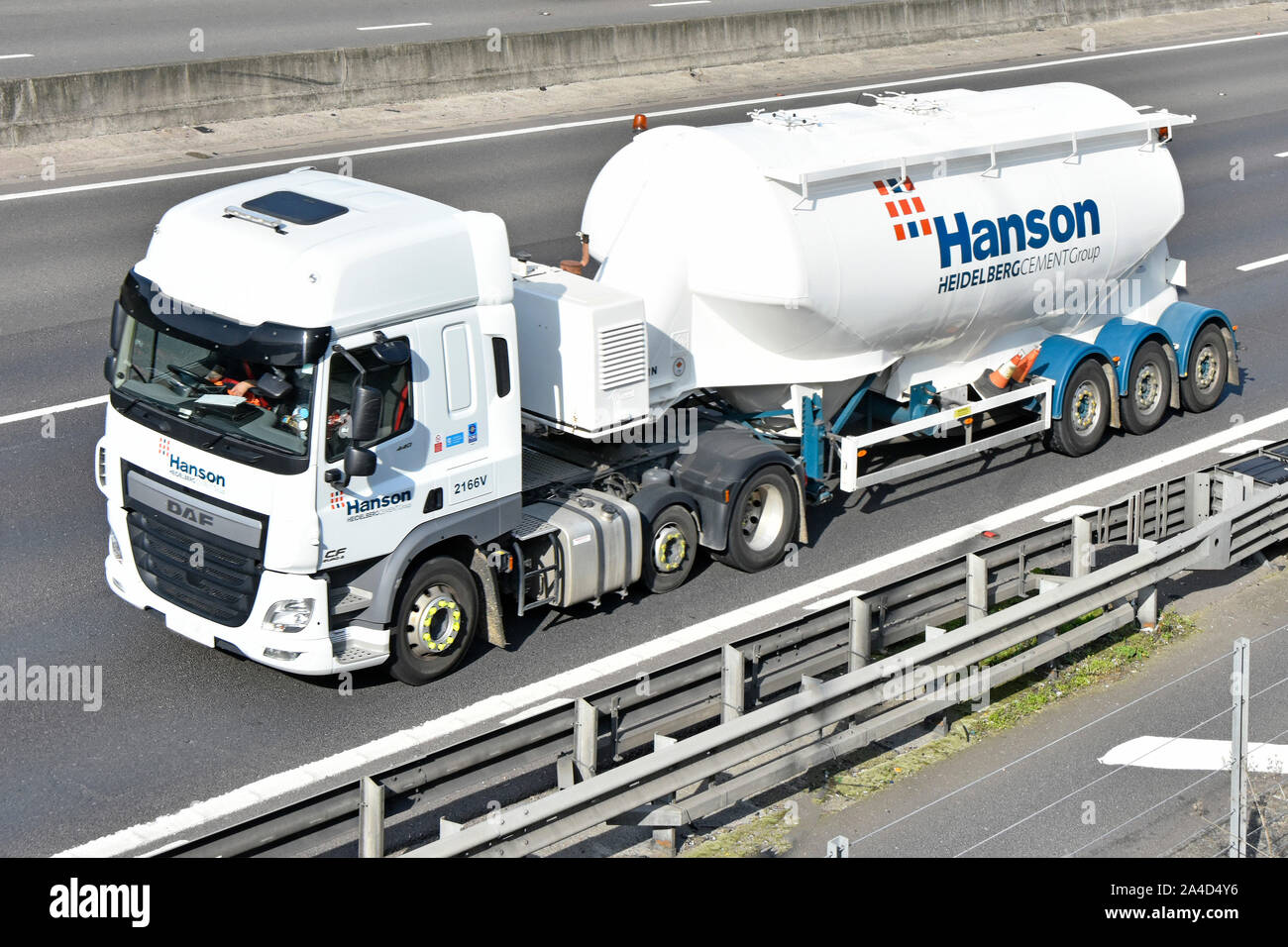 Logo & advertising on side of Hanson Heidelberg bulk cement supply chain business group tanker trailer & hgv lorry truck driving along UK M25 motorway Stock Photo
