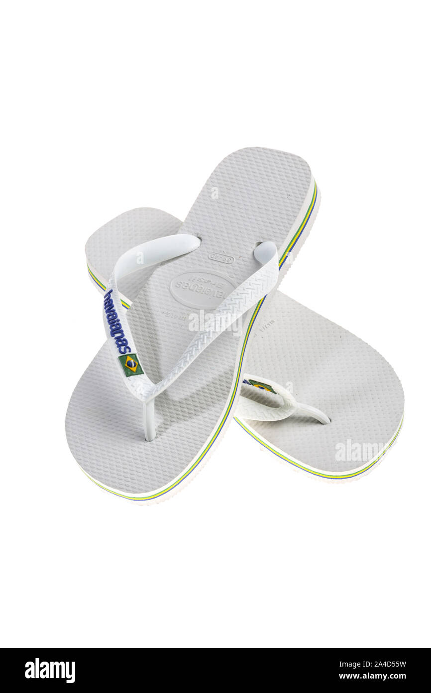 White flip-flops, bath sandals made of plastic with thong bridge and diagonal strap fastening, brand Havaianas, Stock Photo