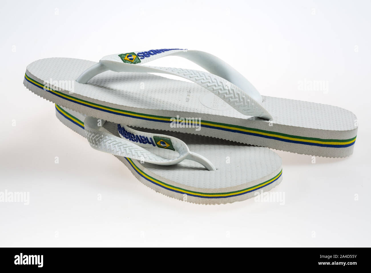 White flip-flops, bath sandals made of plastic with thong bridge and diagonal strap fastening, brand Havaianas, Stock Photo