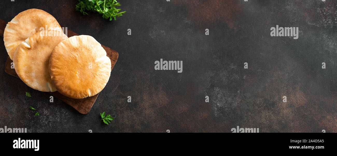 Arabic Pita Flat Bread on dark rustic background, top view, copy space