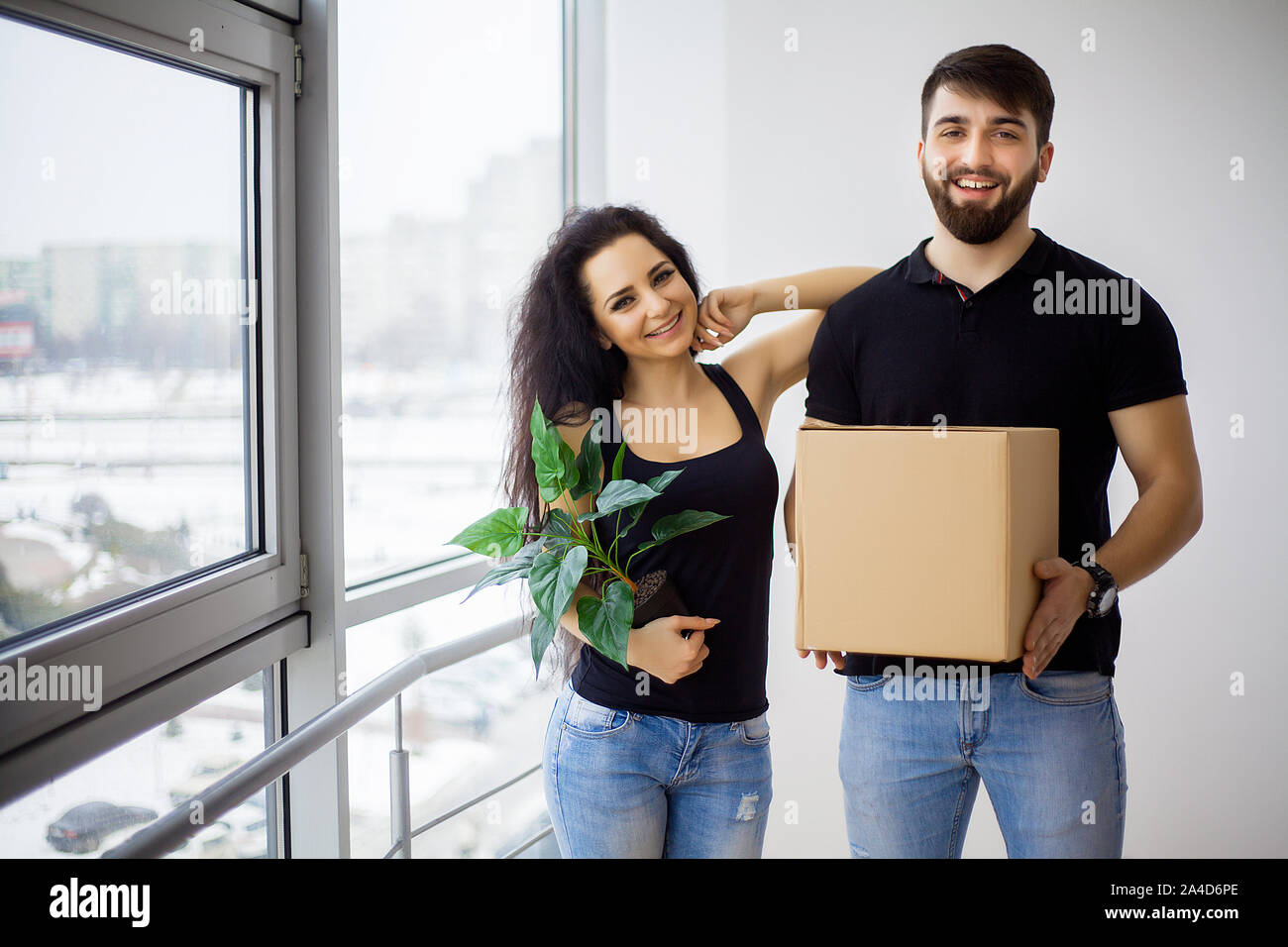 Couple showing keys to new home hugging looking at camera Stock Photo ...