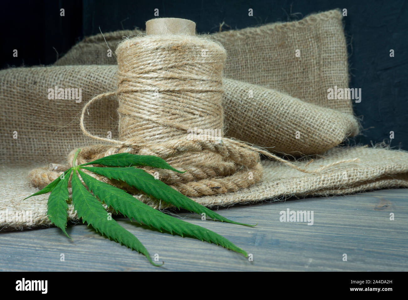 Conceptual types of cannabis products concept image with a cannabis leaf, hemp fiber rope and fabric on an old wooden surface Stock Photo