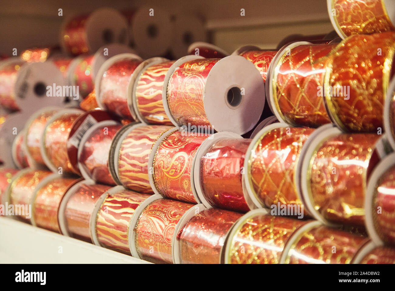 gold and red Christmas ribbons in various patterns displayed stacked on a shelf Stock Photo