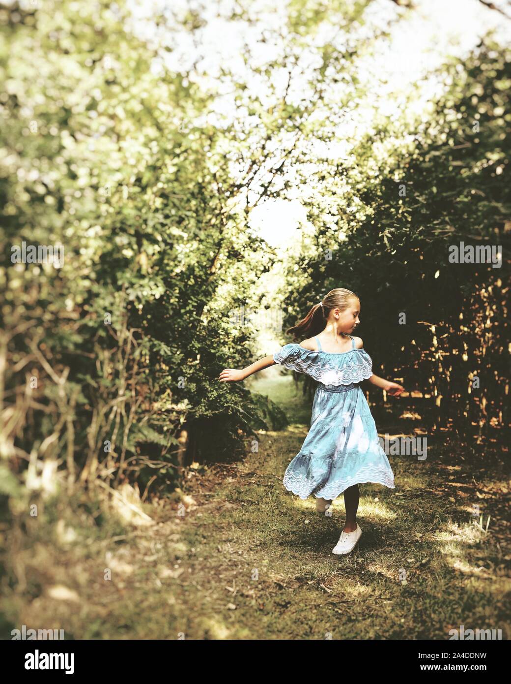 Girl standing in the forest dancing, United Kingdom Stock Photo