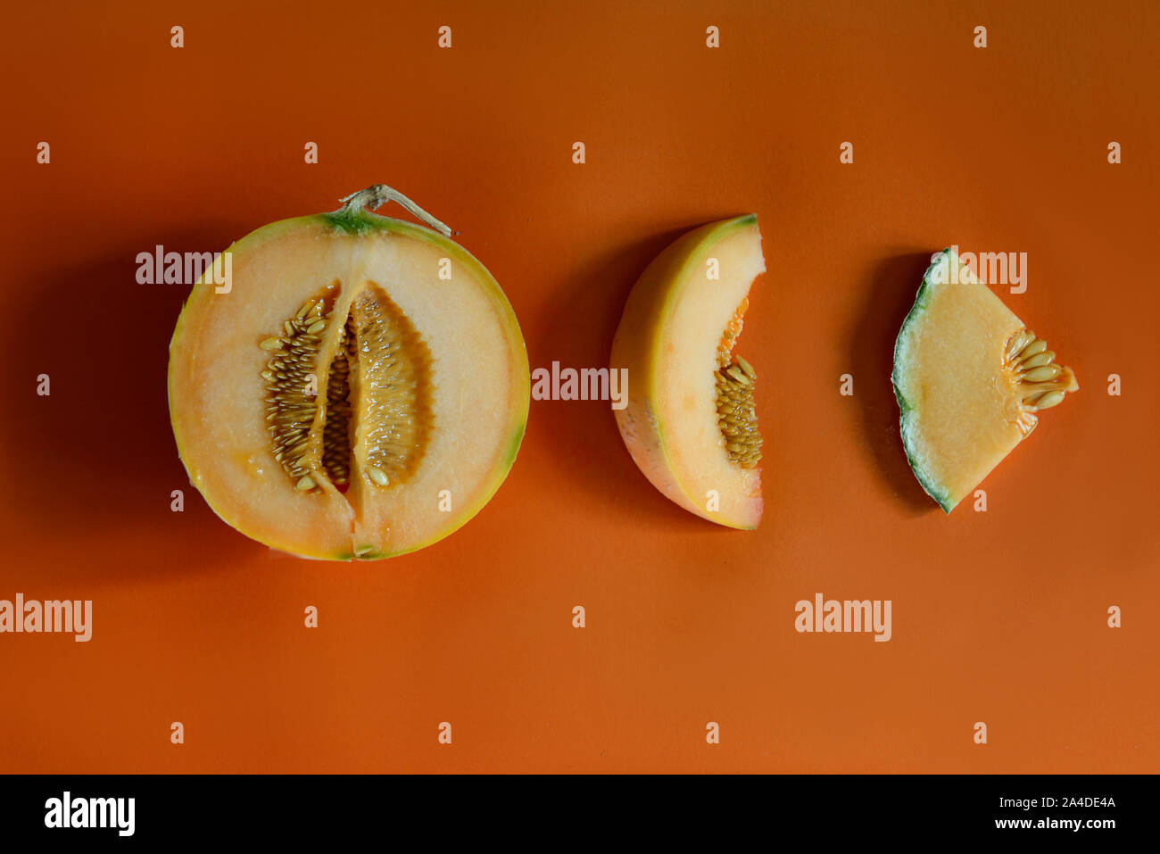 Melon clices sliced isolated on orange background Stock Photo