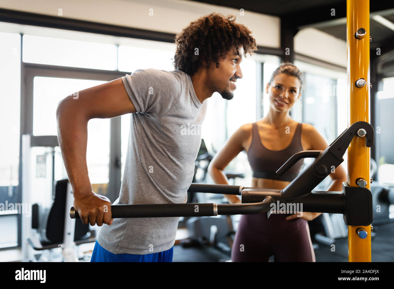 Fitness instructor exercising with client at the gym Stock Photo - Alamy