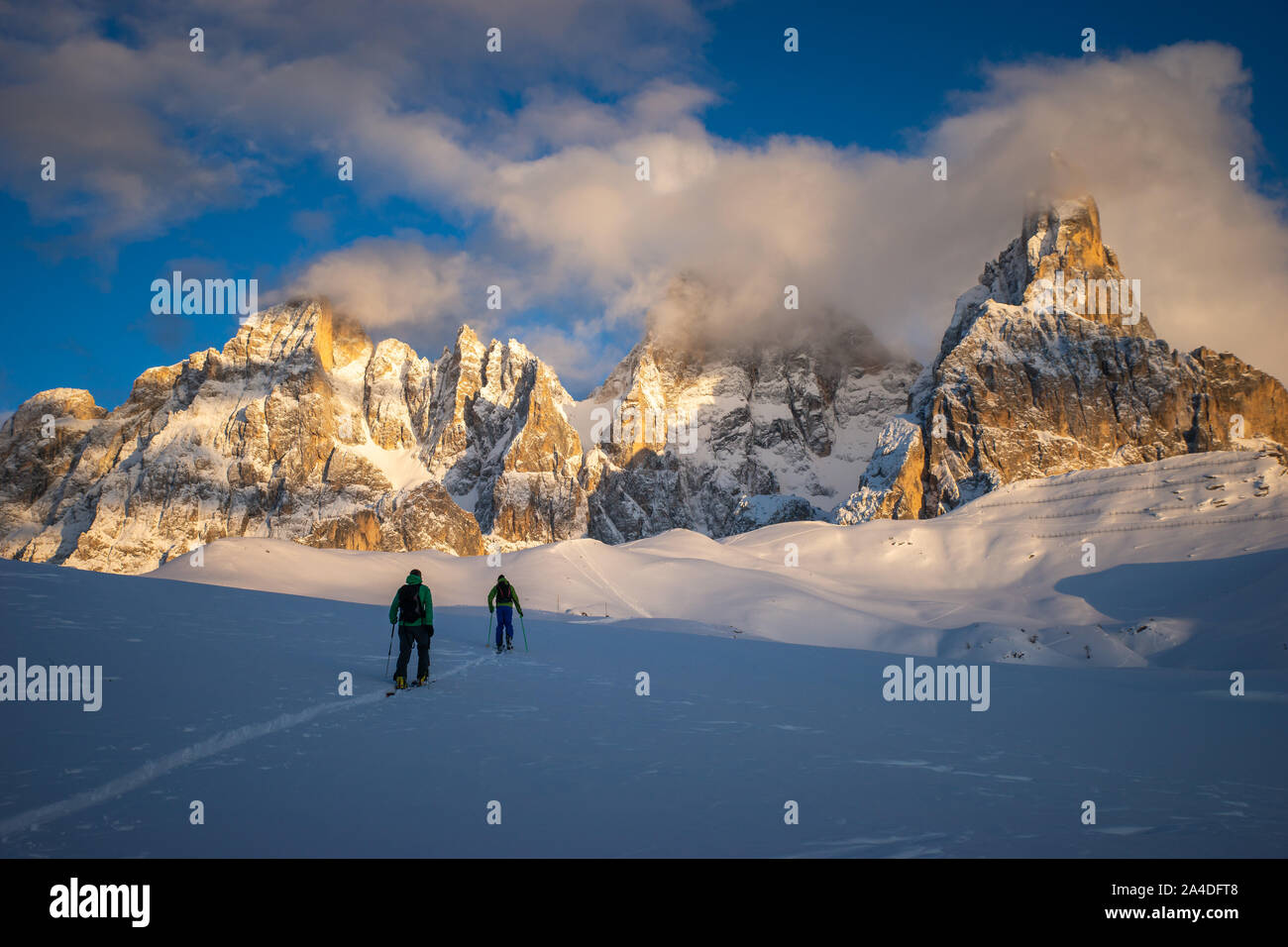 Two men Ski touring in Dolomites at sunset, Italy Stock Photo