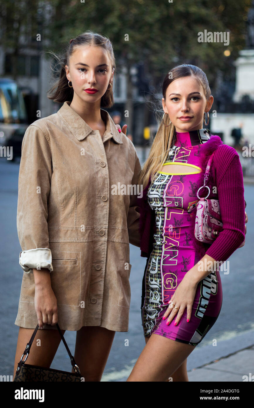 LONDON, ENGLAND - September 15, 2019 Stylish attendees gathering outside 180 Strand for London Fashion Week. Two girls in a beige and purple dress sta Stock Photo