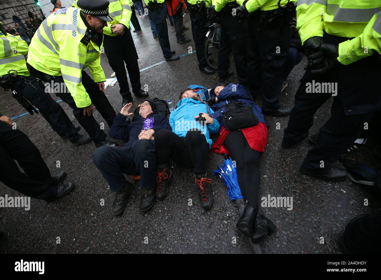 Police talk to protesters blocking the road outside Mansion House in the City of London, during an Extinction Rebellion (XR) climate change protest. Stock Photo