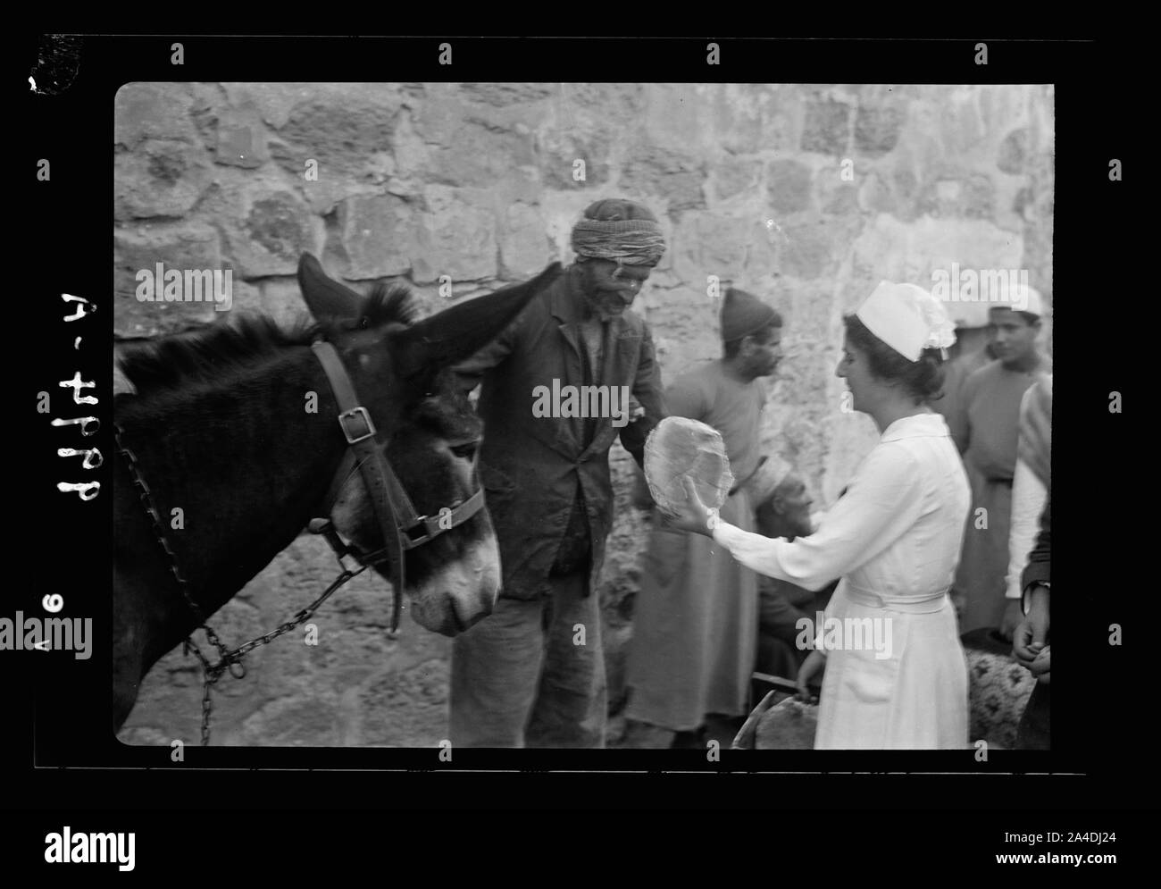 The raising of the siege of Jerusalem. Nurse handing over loaf of bread to an old town scavenger Stock Photo