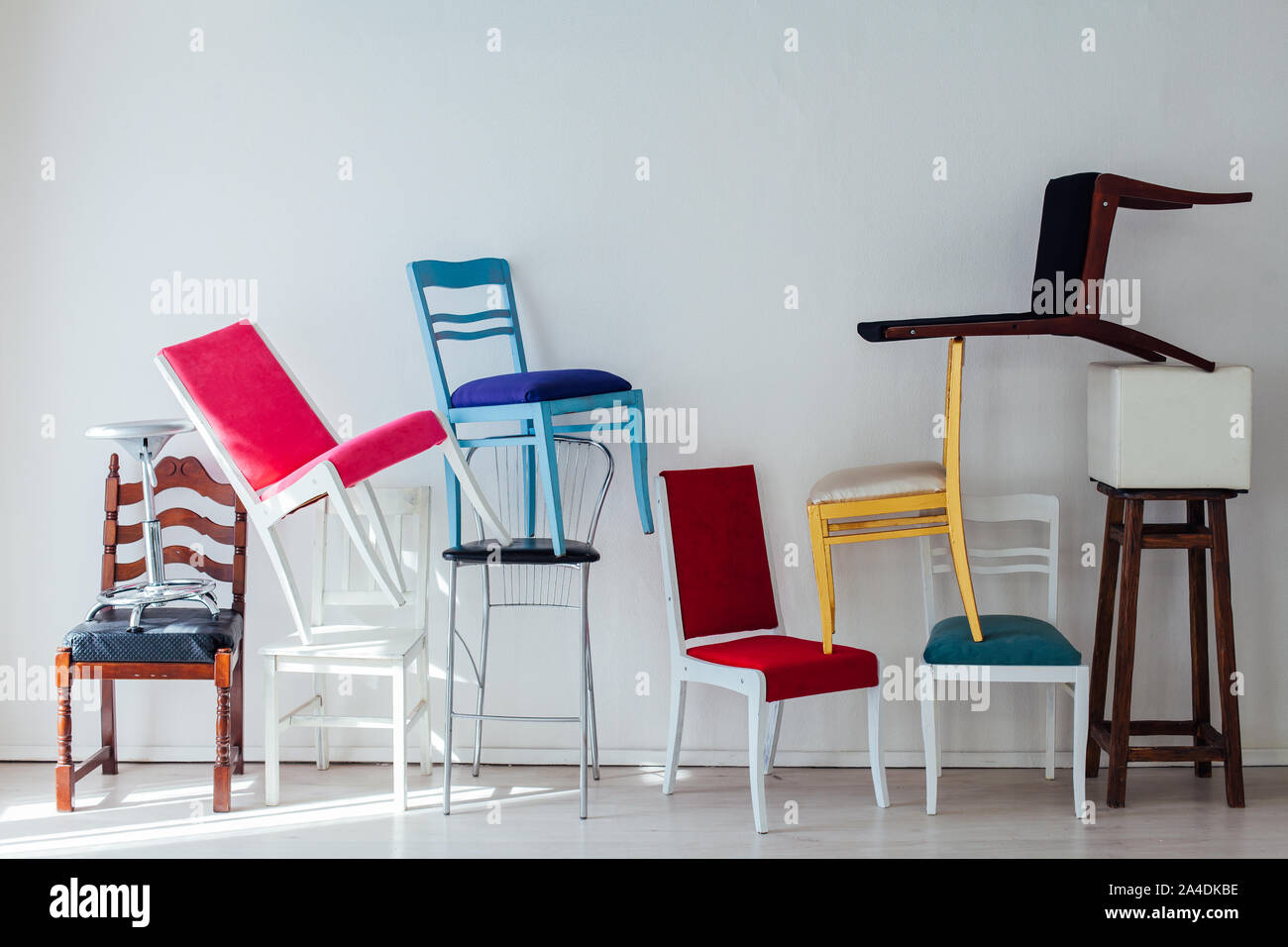many different chairs stand in the white room Stock Photo