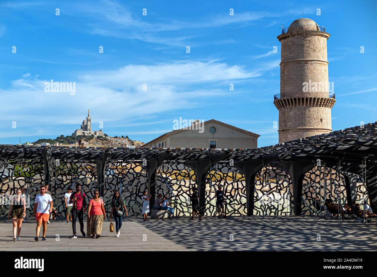 VISITORS AT THE MUCEM, MUSEUM OF THE CIVILIZATIONS OF EUROPE AND THE MEDITERRANEAN, THE THE TOWER OF THE FORT SAINT-JEAN AND THE NOTRE-DAME DE LA GARDE BASILICA, MARSEILLE, BOUCHES-DU RHONE, FRANCE Stock Photo