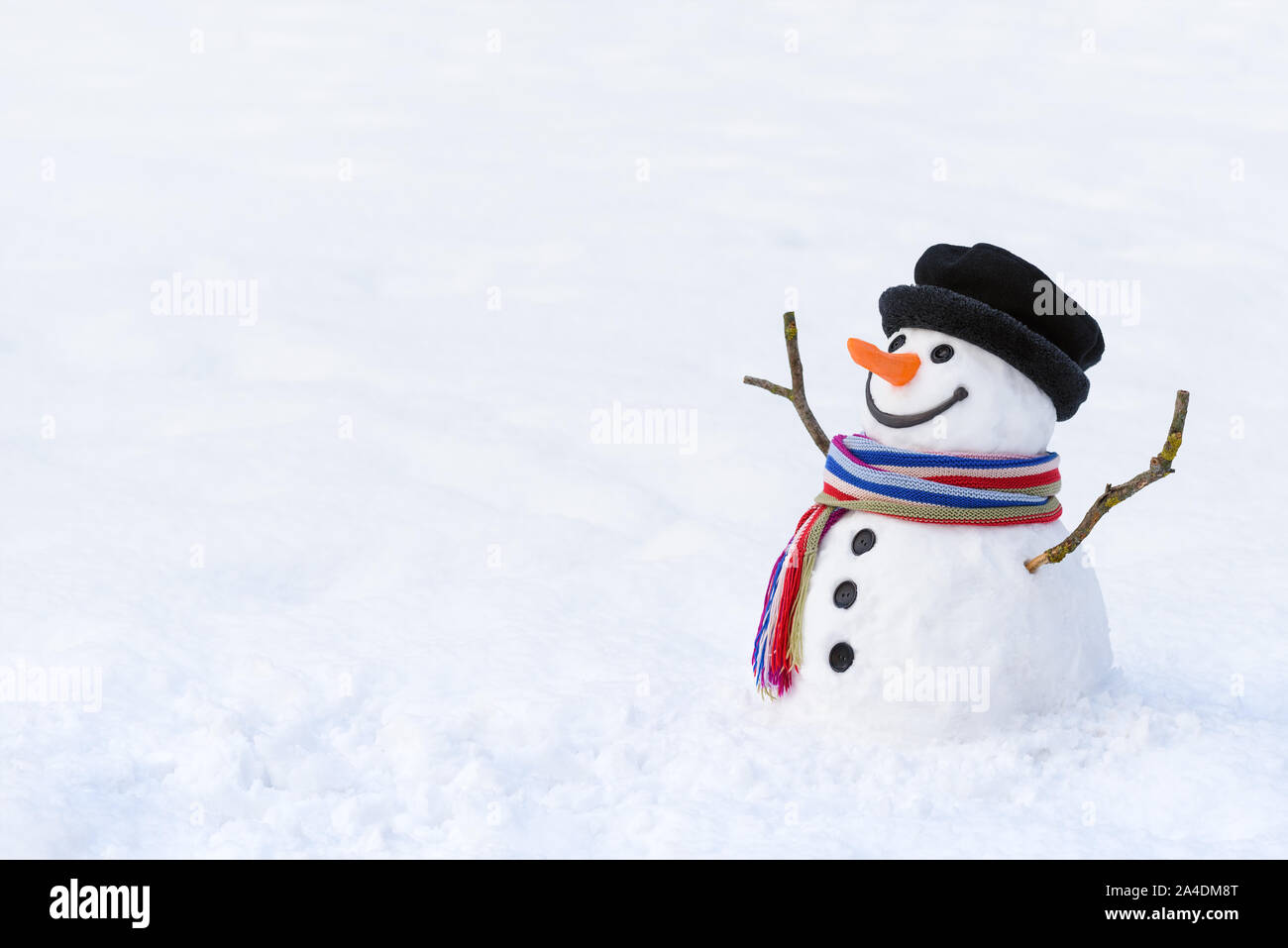 Winter dream of children. Funny snowman with a colorful scarf. Copy space for text Stock Photo