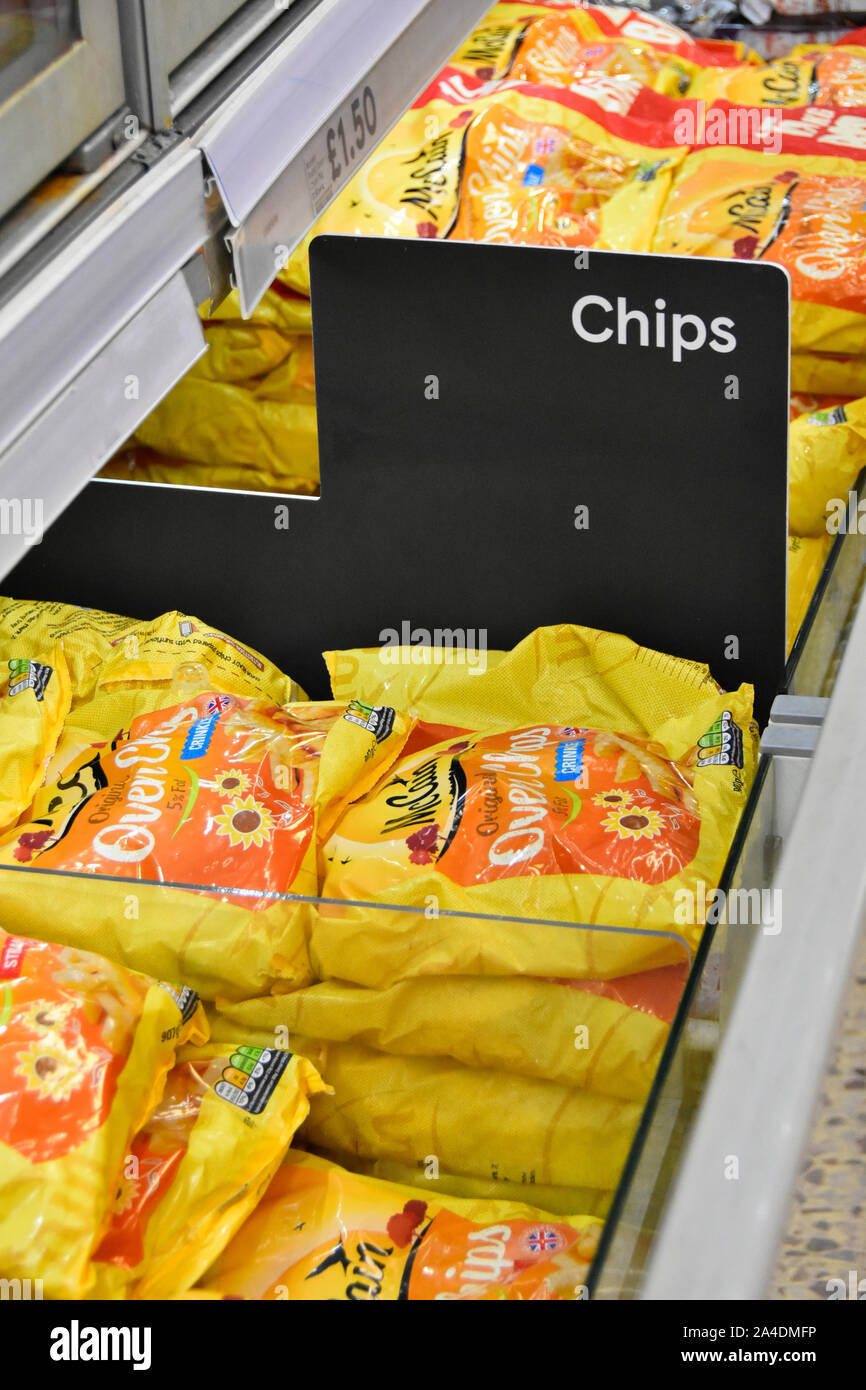 Close up of Chips sign in frozen food supermarket store self service display cabinet with potato chips in plastic packaging bag London England UK Stock Photo
