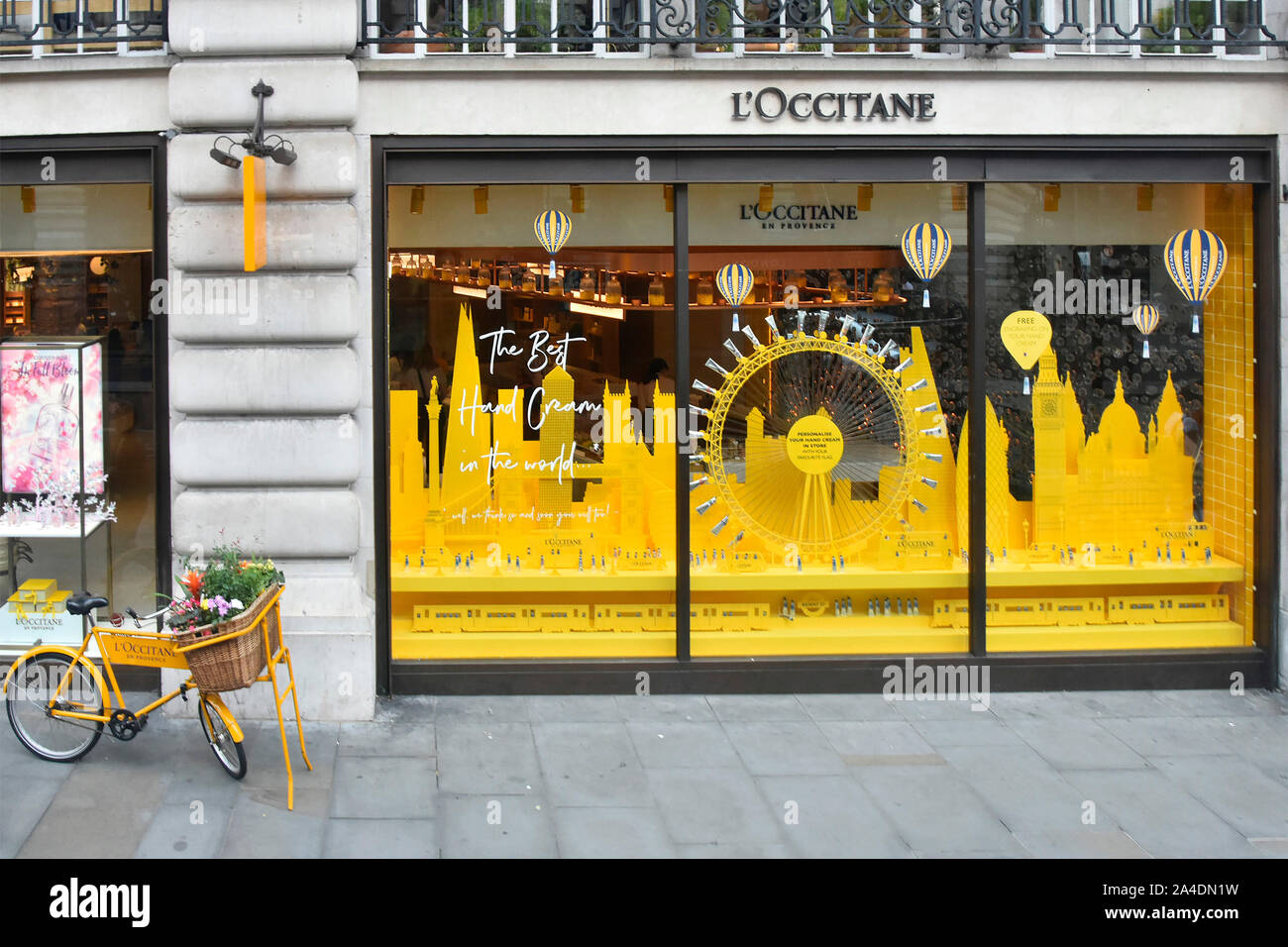 L’Occitane a personal care retail business from Provence looking down from above at  shop front window display & bike Regent Street London England UK Stock Photo
