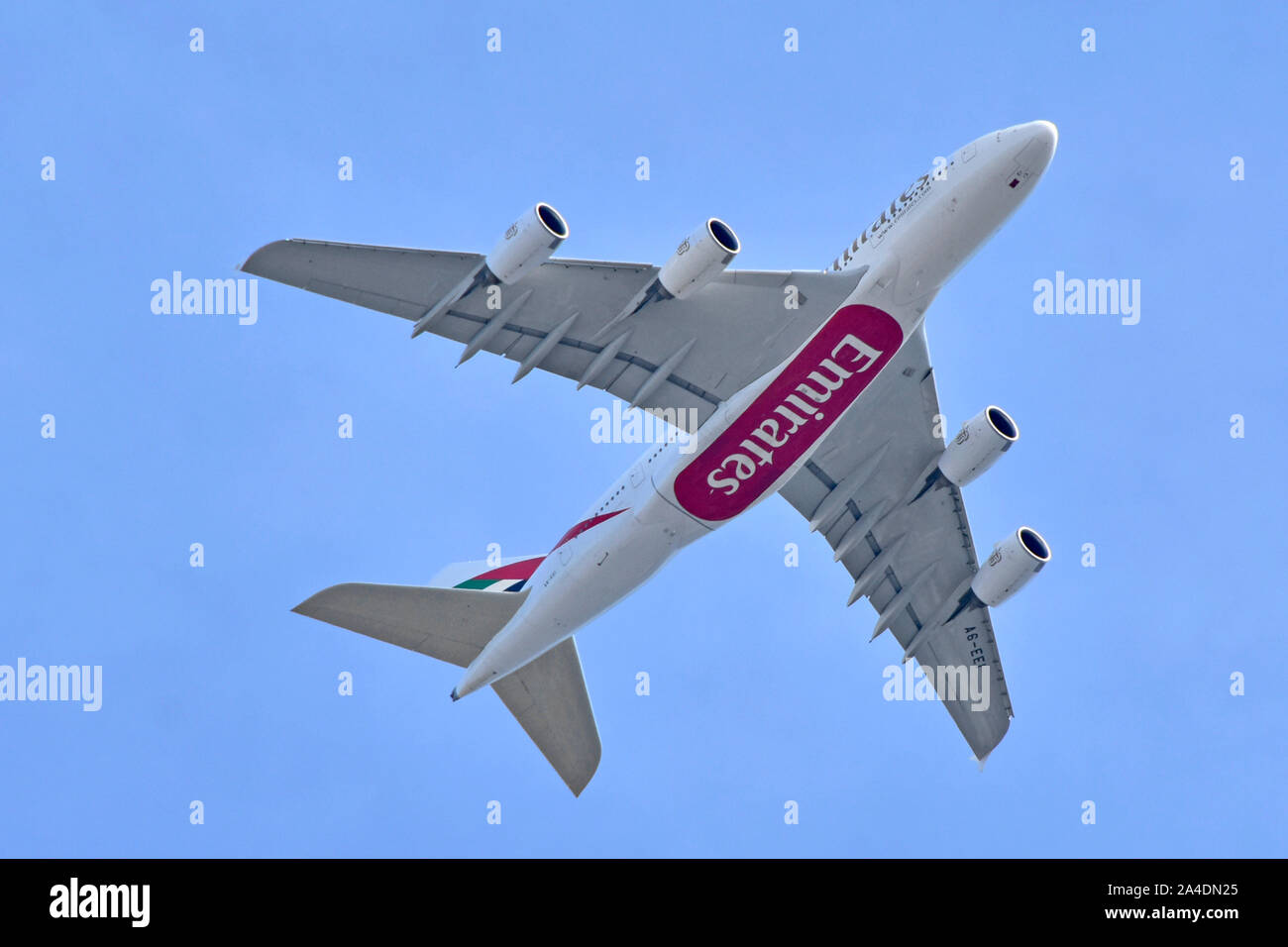 Close up underside view of Emirates airline business Airbus A380 800  jet airplane aeroplane in flight plane low over London on Heathrow approach UK Stock Photo