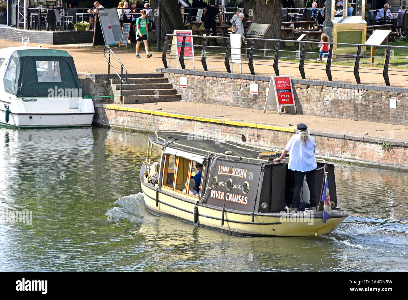 Small sightseeing river Great Ouse cruise tour boat trip returns to riverside pickup point  with passengers Ely Cambridgeshire East Anglia England UK Stock Photo