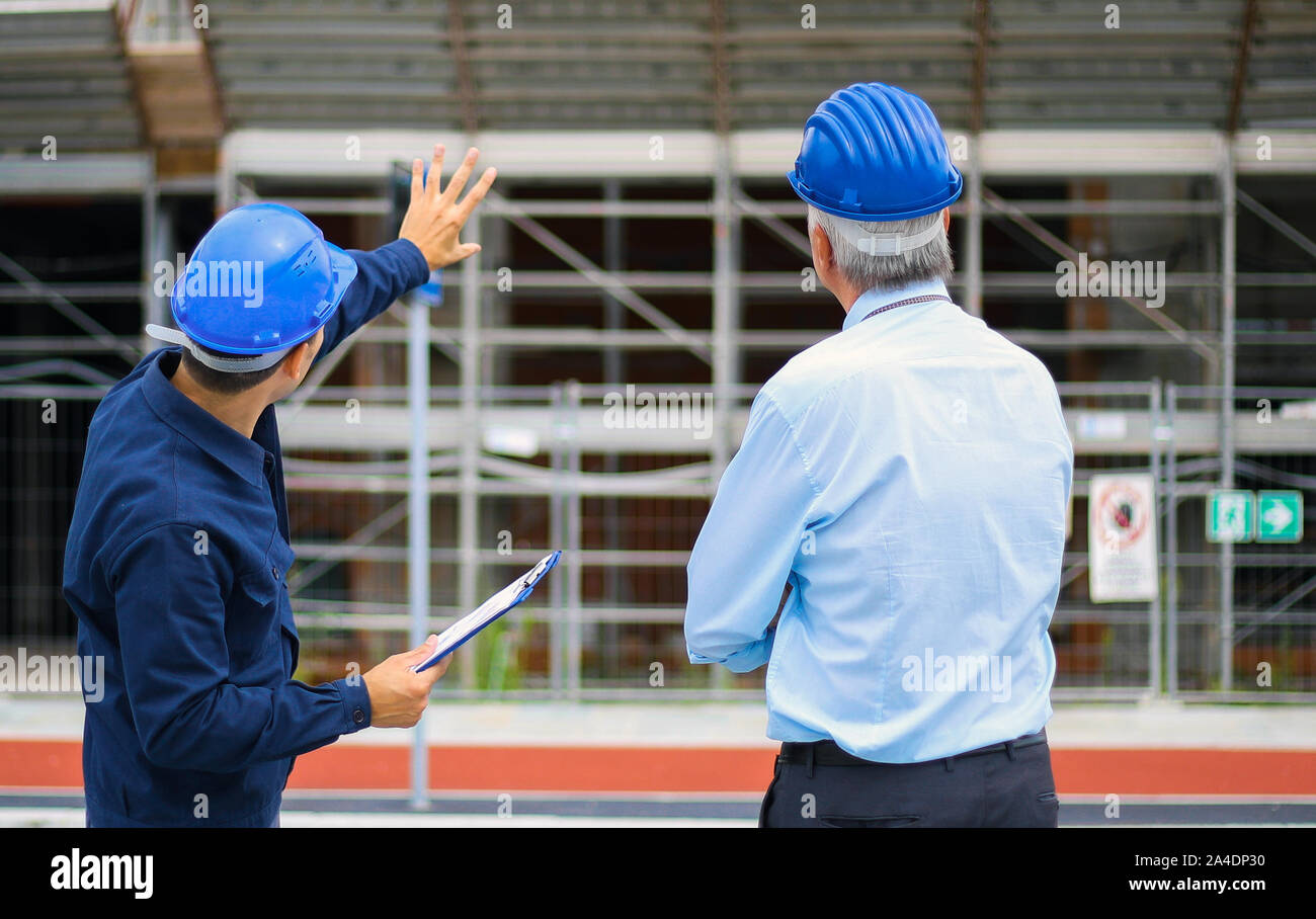 Two architect developers reviewing building plans at construction site Stock Photo