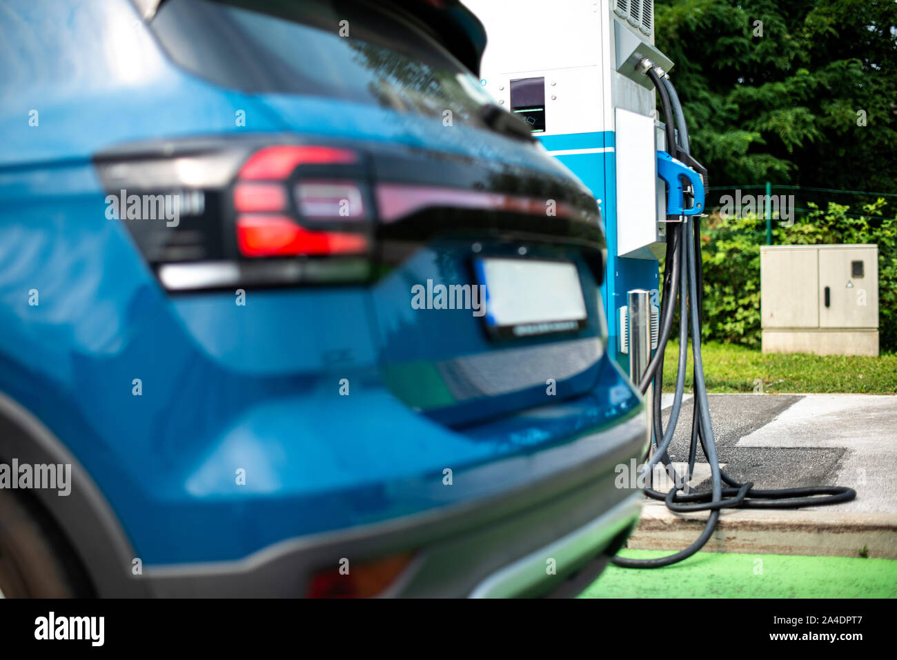 Electric car on gas station. Blue car and electric plug for charging