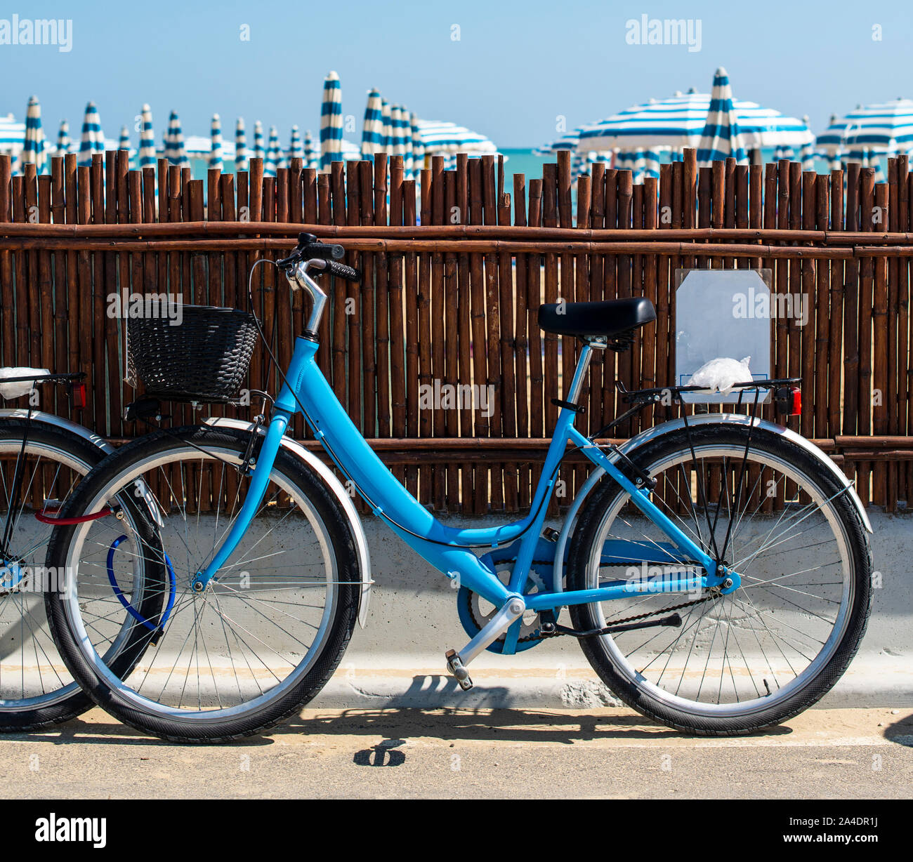 Rental bikes on the beach. Blue bicycles on the street. Many beach