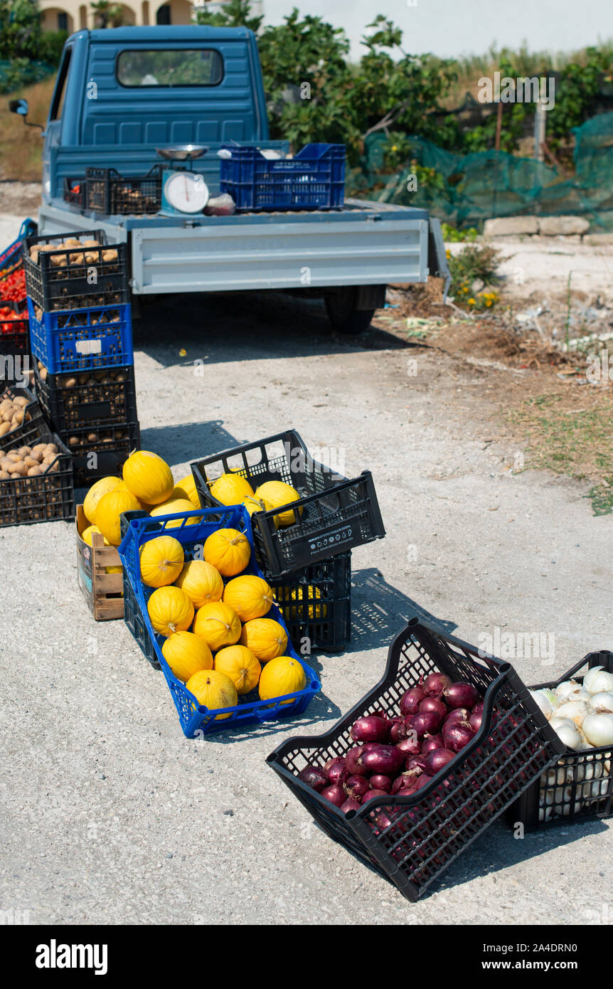 Small italian apo truck. Street vegetable market. Farmer sale melons and onion on the street in Italy. Stock Photo