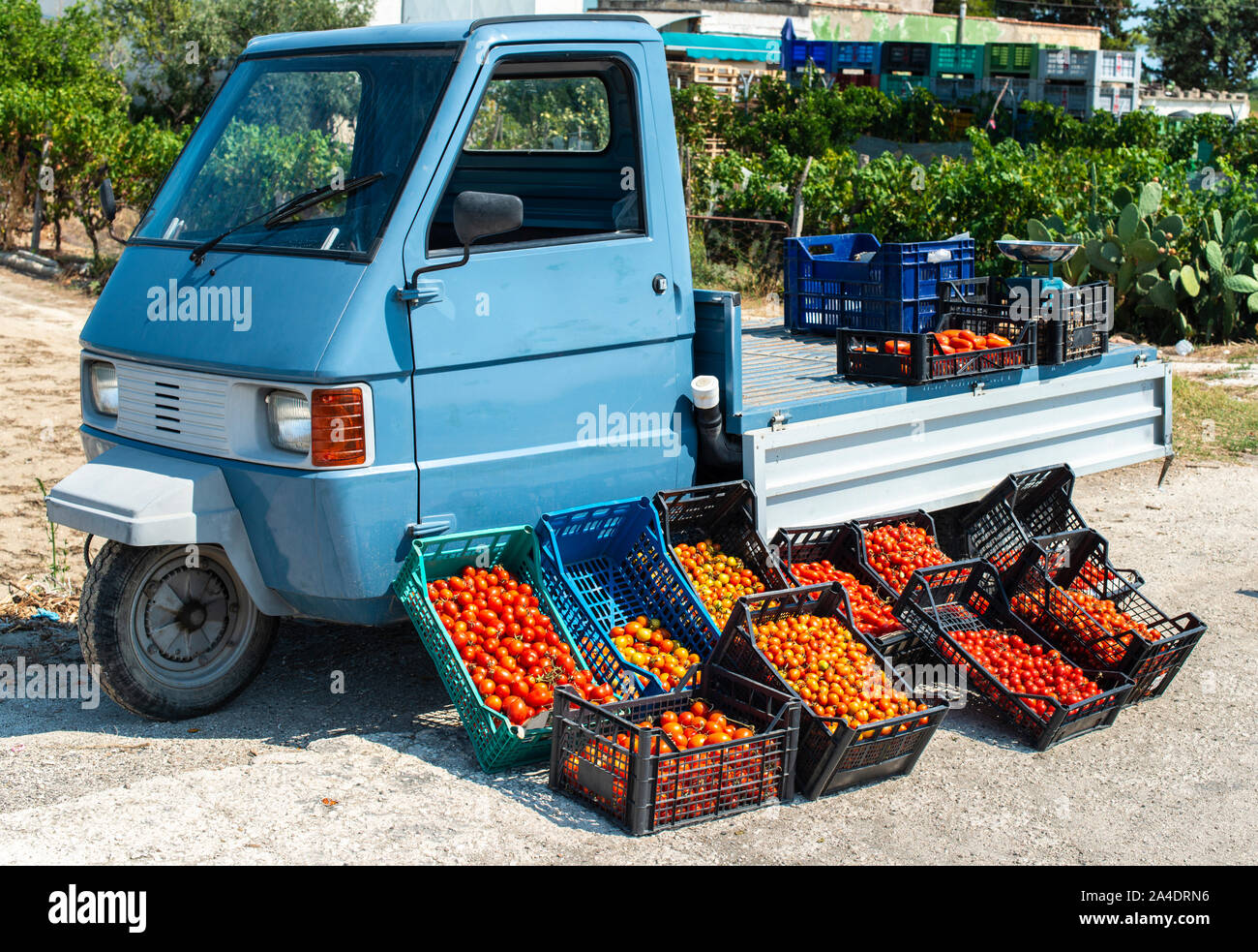 Small italian apo truck with tomatoes. Street market. Farmer sale tomatoes on the street in Italy. Stock Photo