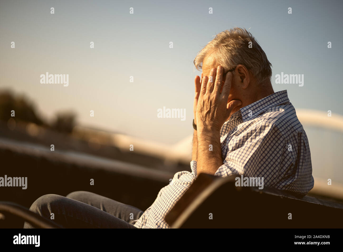 Outdoor portrait of senior man who is having headache. Stock Photo