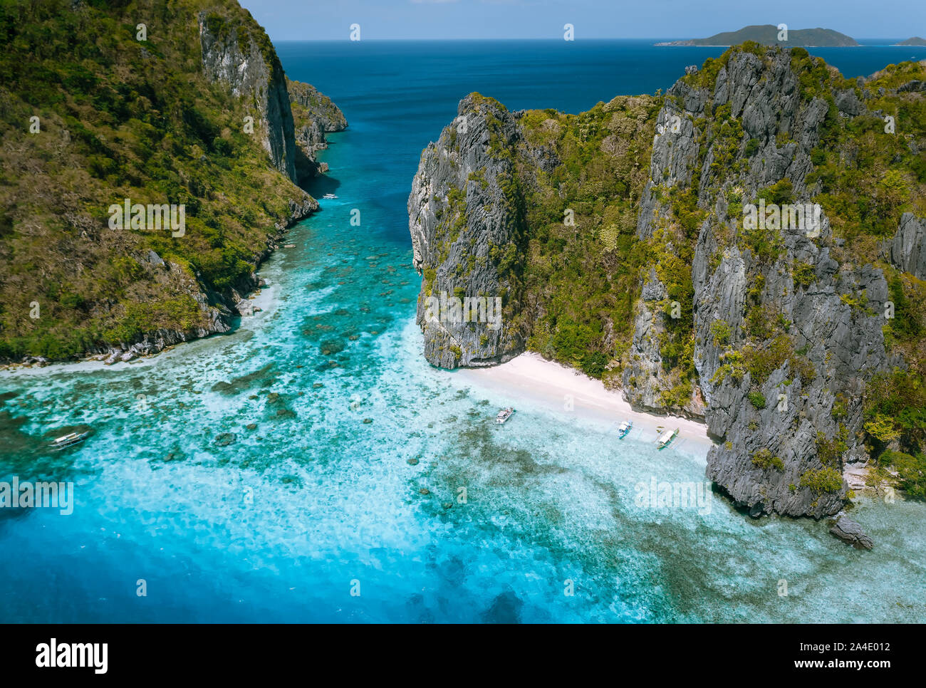 El Nido, Palawan, Philippines. Aerial view of tropical sea stack Island with tourist boats moored at white sandy beach Stock Photo