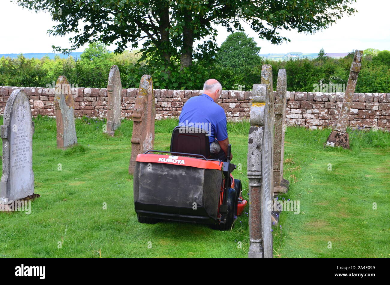Cutting the grass in a graveyard Stock Photo Alamy