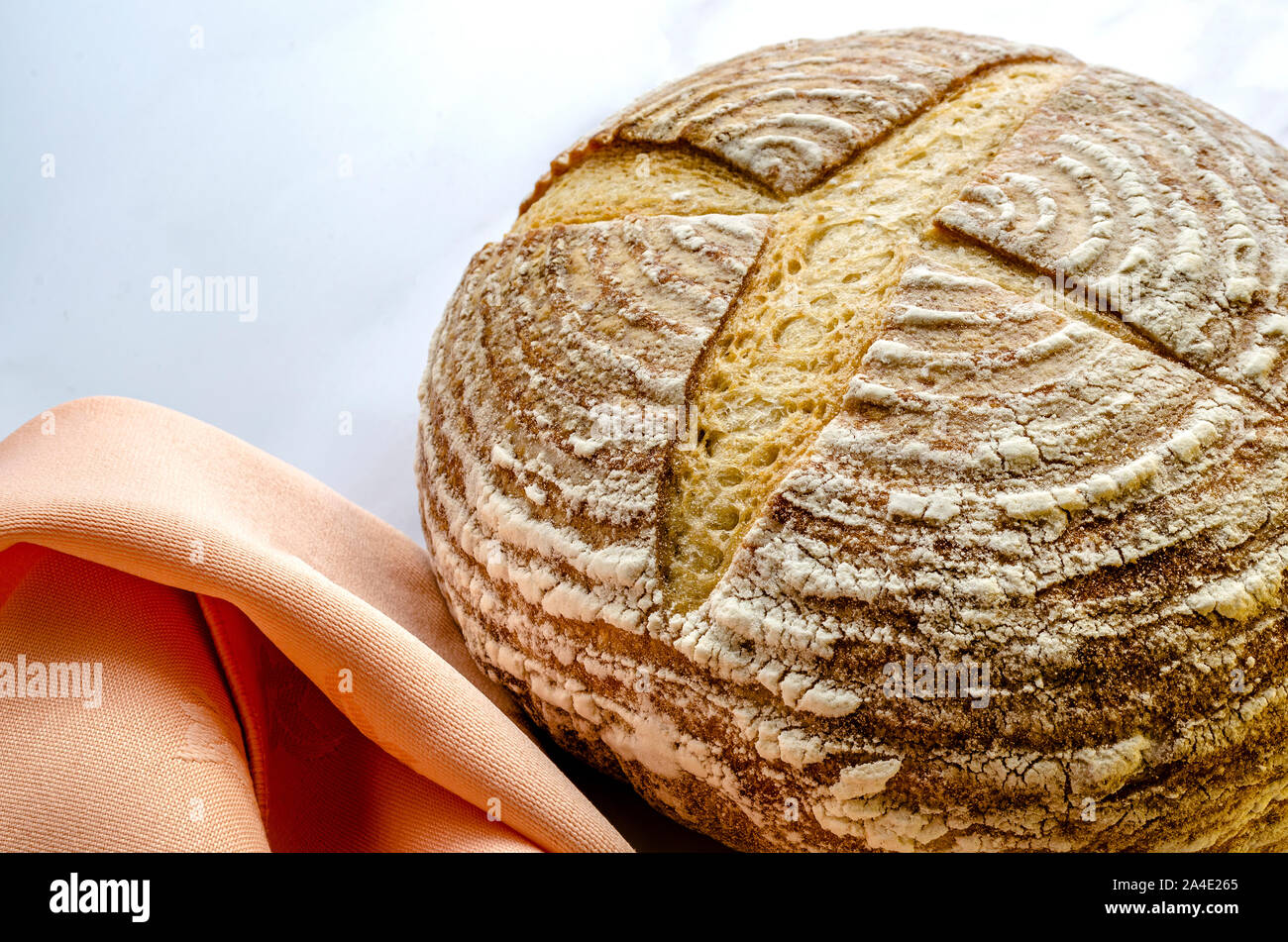 Freshly baked sourdough bread showing the traditional markings standing