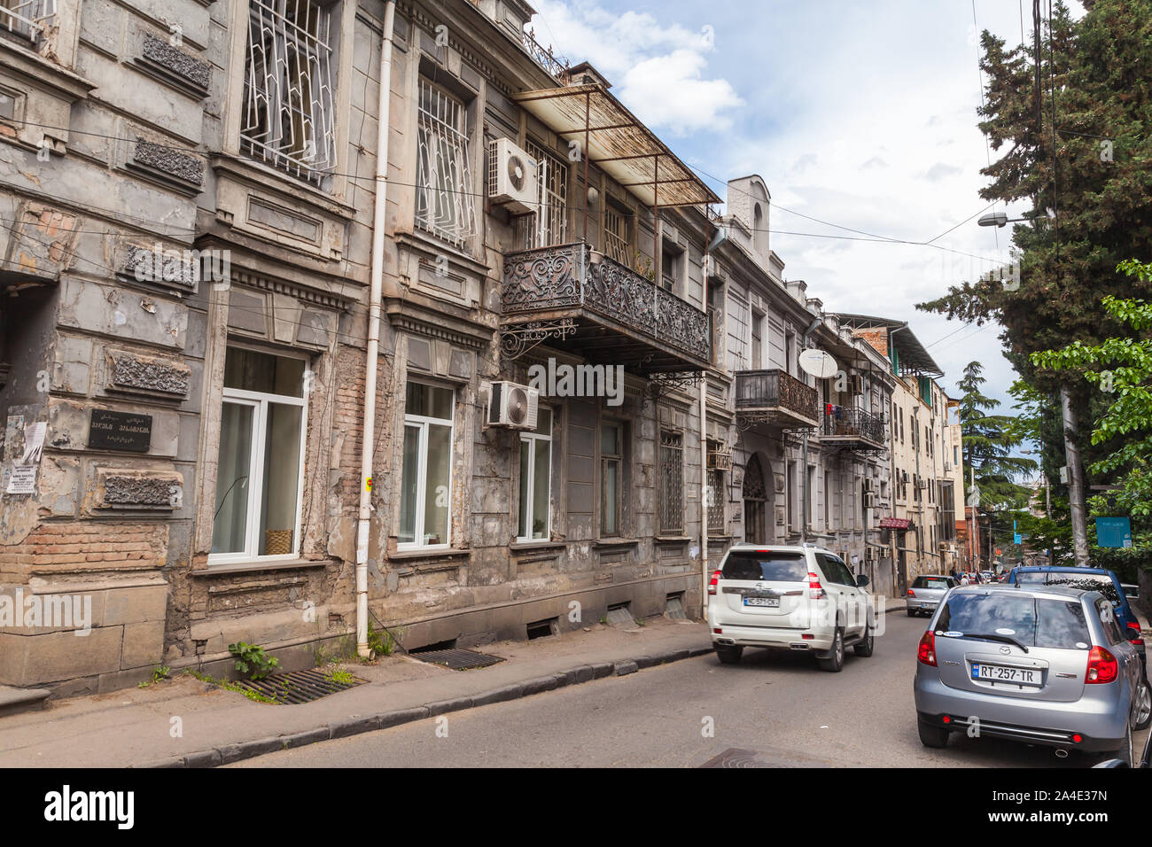 Tbilisi, Georgia - May 03, 2019: Tbilisi old street view with cars parked near living houses with traditional wooden balconies Stock Photo