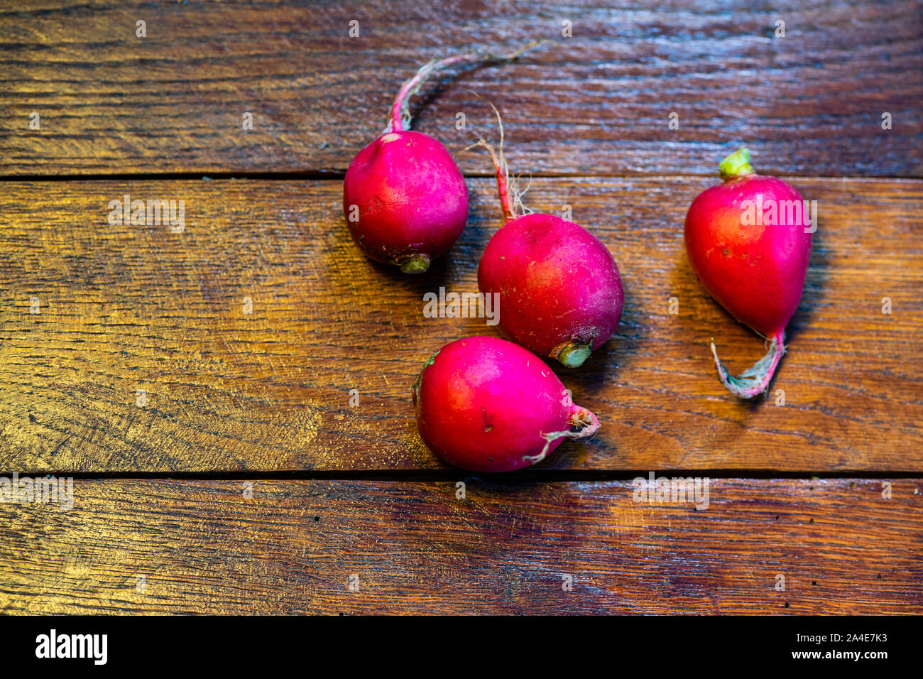 Fresh red radishes on a wooden board. Stock Photo