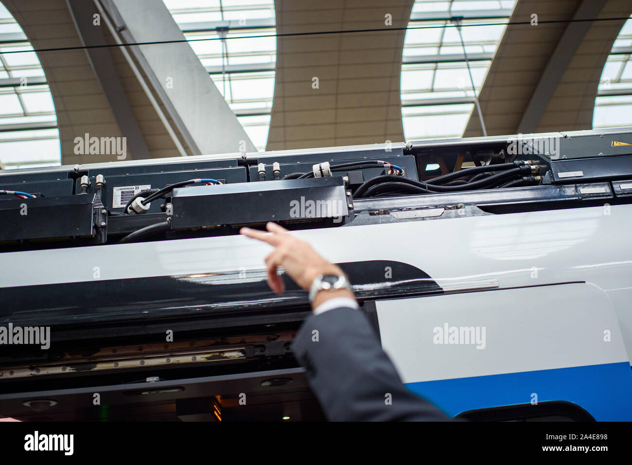 Kiel, Germany. 14th Oct, 2019. An employee of Stadler Pankow GmbH points to the battery carrier on the roof of the railcar during the presentation of one of the 'FLIRT battery' test trains at Kiel main station. Stadler and the Schleswig-Holstein public transport association have signed a supply contract for 55 battery-powered railcars. The first battery multiple units are to be deployed in the northern and eastern networks of Schleswig-Holstein at the end of 2022. Credit: Gregor Fischer/dpa/Alamy Live News Stock Photo