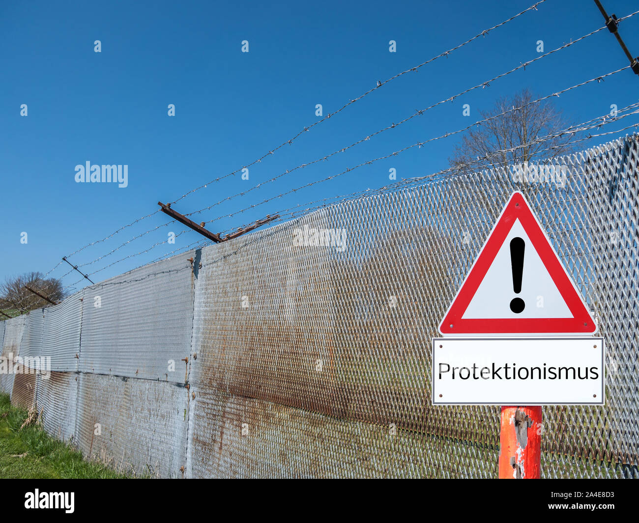 Border fence with warning sign protectionism in German Stock Photo