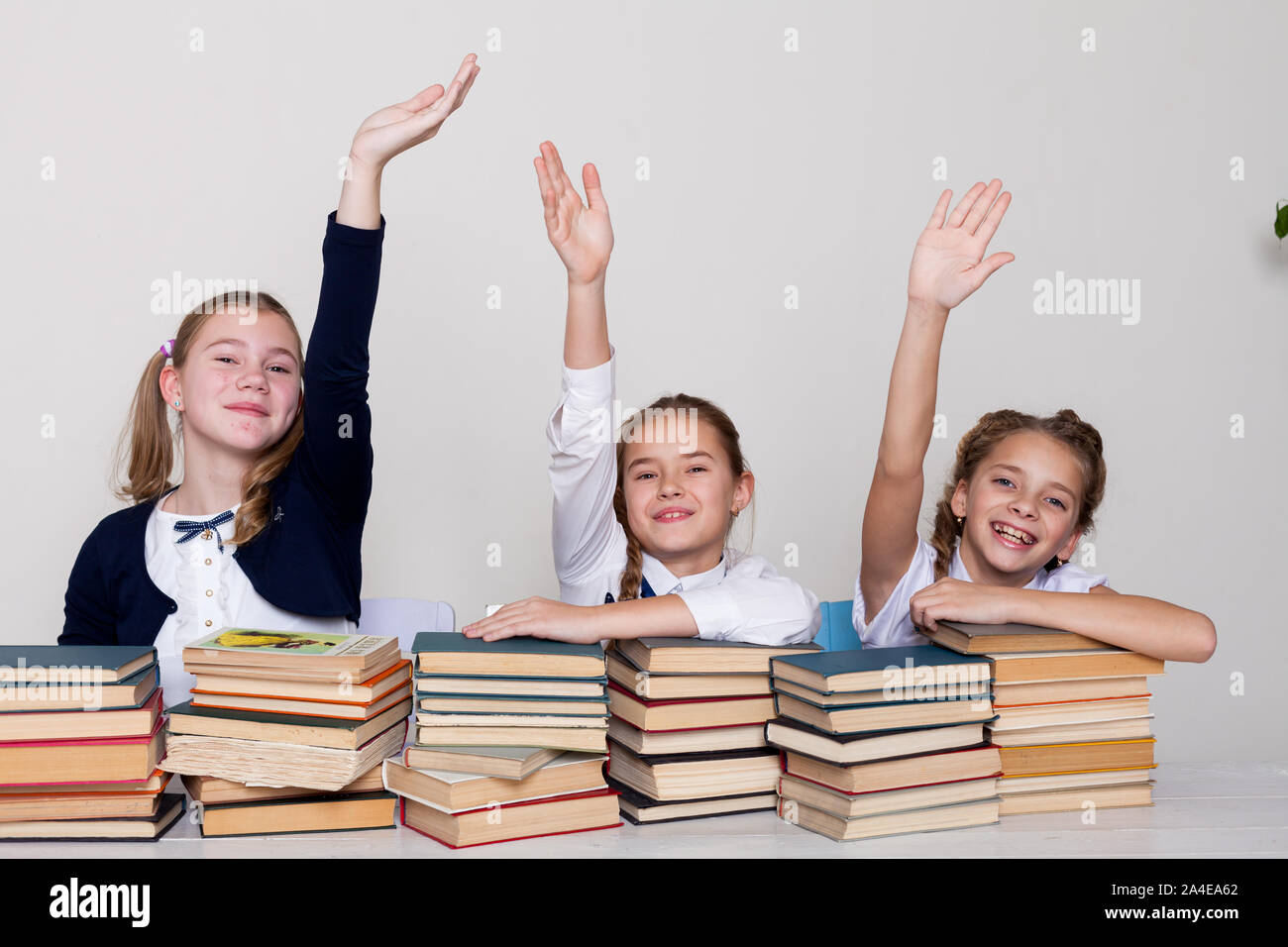 three schoolgirl girls at the desk study books Stock Photo - Alamy