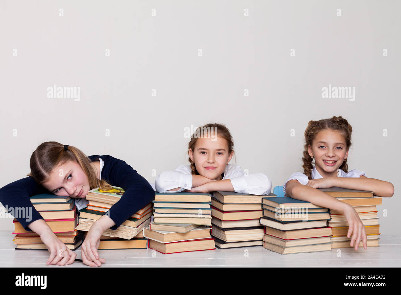 three schoolgirl girls at the desk study books Stock Photo - Alamy