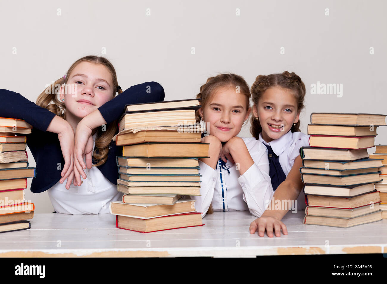 three schoolgirl girls at the desk study books Stock Photo - Alamy