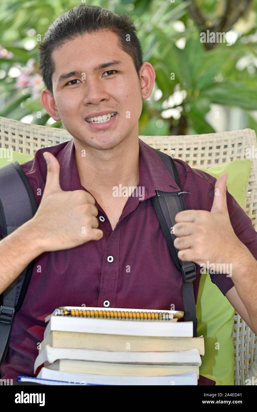 Male Student With Thumbs Up With Notebooks Stock Photo - Alamy