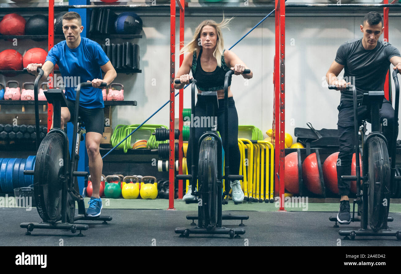 Athletes doing air bike indoor Stock Photo