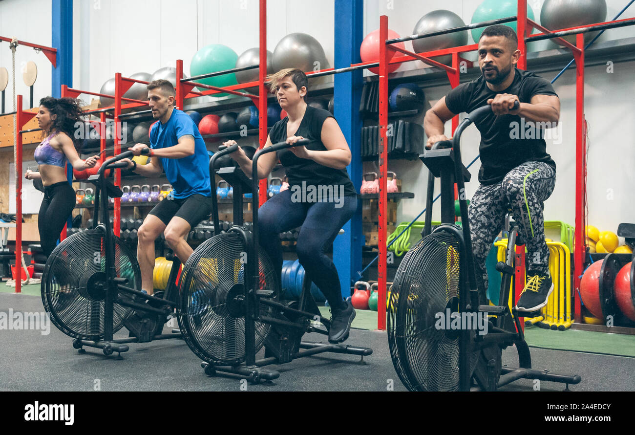 Athletes doing air bike indoor Stock Photo