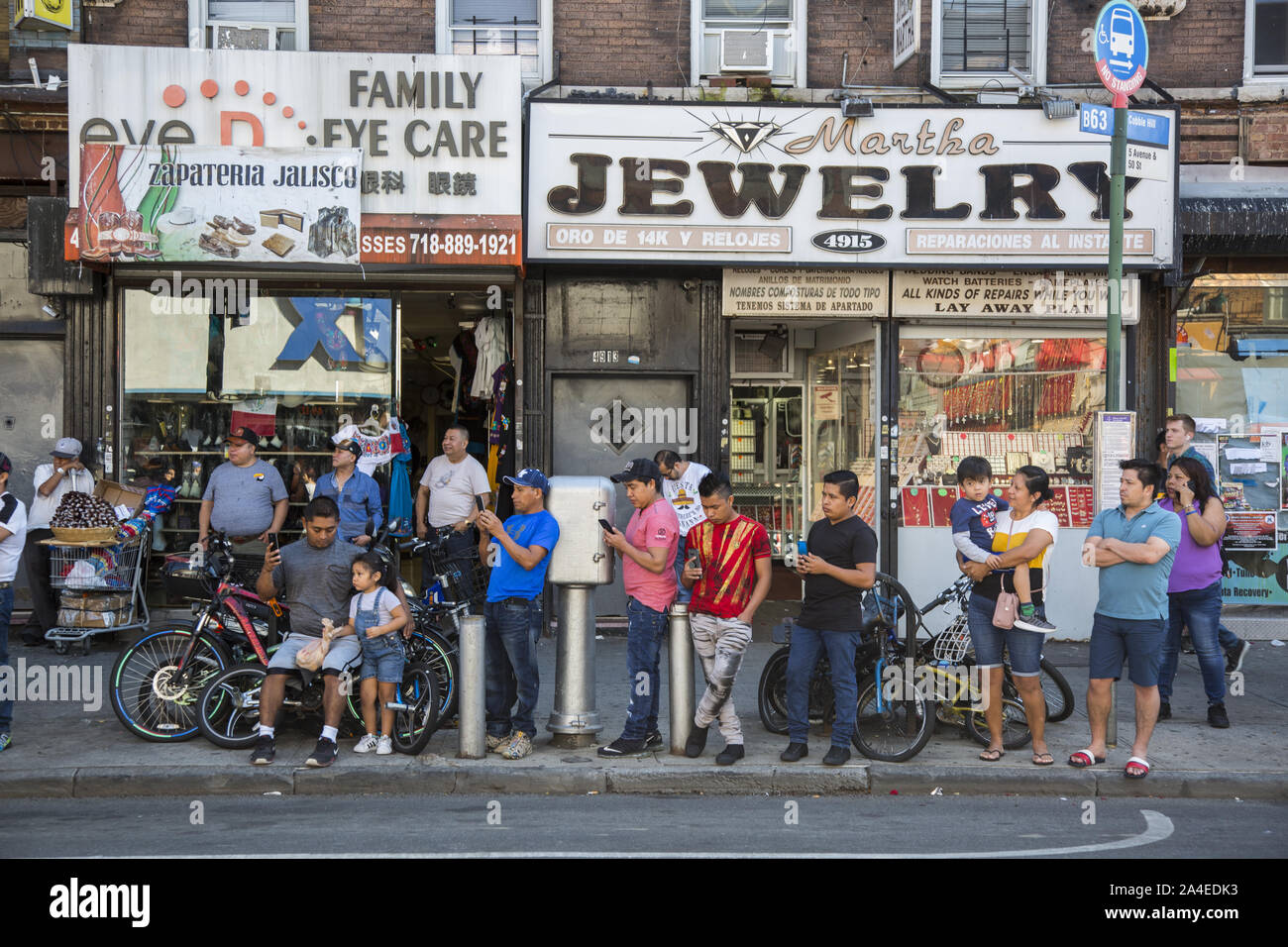 The Mexican Independence Day Parade in Sunset Park, Brooklyn, NY, a neighborhood with a large Mexican and Hispanic population from other Latin American countries. Mostly young spectators with phones out waiting to record the parade as it passes by. Stock Photo