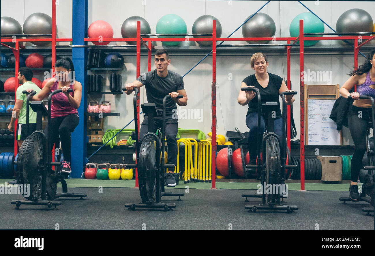 Athletes doing air bike indoor Stock Photo