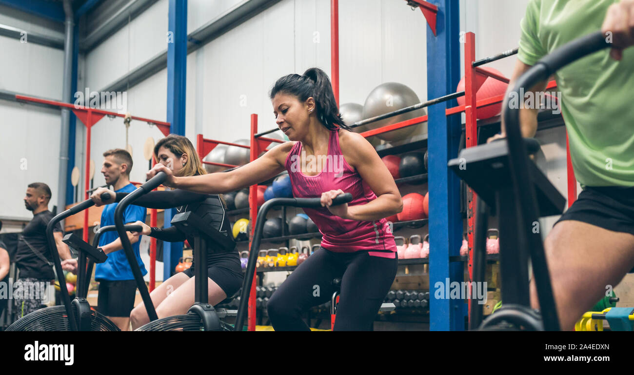 Athletes doing air bike indoor Stock Photo