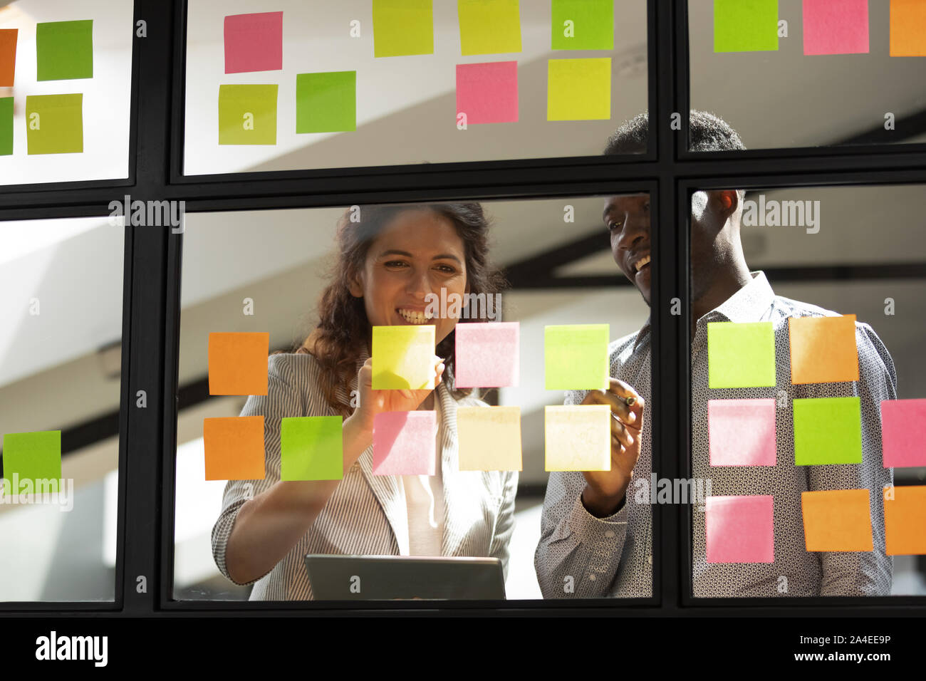 Diverse workmates writing new thoughts fresh ideas on sticky notes Stock Photo