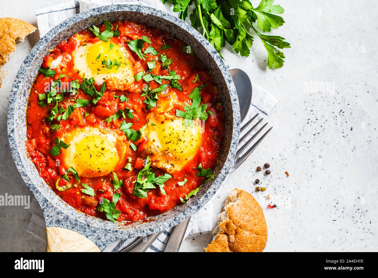 Traditional shakshuka in a pan. Fried eggs in tomato sauce with herbs